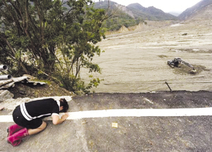 14日，高雄小林村附近的公路上，一名村民悼念在泥石流中喪生的親人。