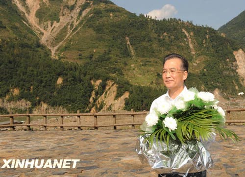 溫家寶總理十分關注災后重建進展情況。在國慶節和中秋佳節即將來臨之際，他第8次踏上了一直牽掛的這塊土地。在9月24日至26日的三天時間里，他奔波穿行于地震重災區的城鄉間，為節省時間，吃飯盡量安排在火車上；連續兩個晚上主持召開會議，就災后恢復重建的一系列重大問題進行研究部署。這是9月24日，溫家寶在青川縣紅光鄉東河口村地震遺址祭奠臺獻花。新華社記者黃敬文攝
