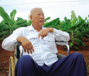 陳光保在自己的農場里，他身后就是一片香蕉林(中青報蔣昕捷供圖)