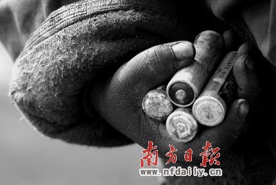     生活在垃圾場的兒童把廢舊電池當玩具