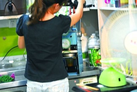 昨日，沙坪壩區(qū)一飲料店，店員在用添加劑勾兌果汁