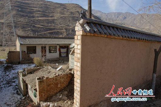 甘肅漳縣殪虎橋鄉東橋村的“遮羞墻”擋住農戶房屋（人民網記者 高翔 張鵬 隋欣 攝）