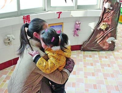 江都商貿(mào)幼兒園一位老師在擁抱該園的孩子。因?yàn)樯婕笆召M(fèi)，作為該園精品教育的一個(gè)項(xiàng)目，老師的擁抱行為也被質(zhì)疑。 董鑫 攝